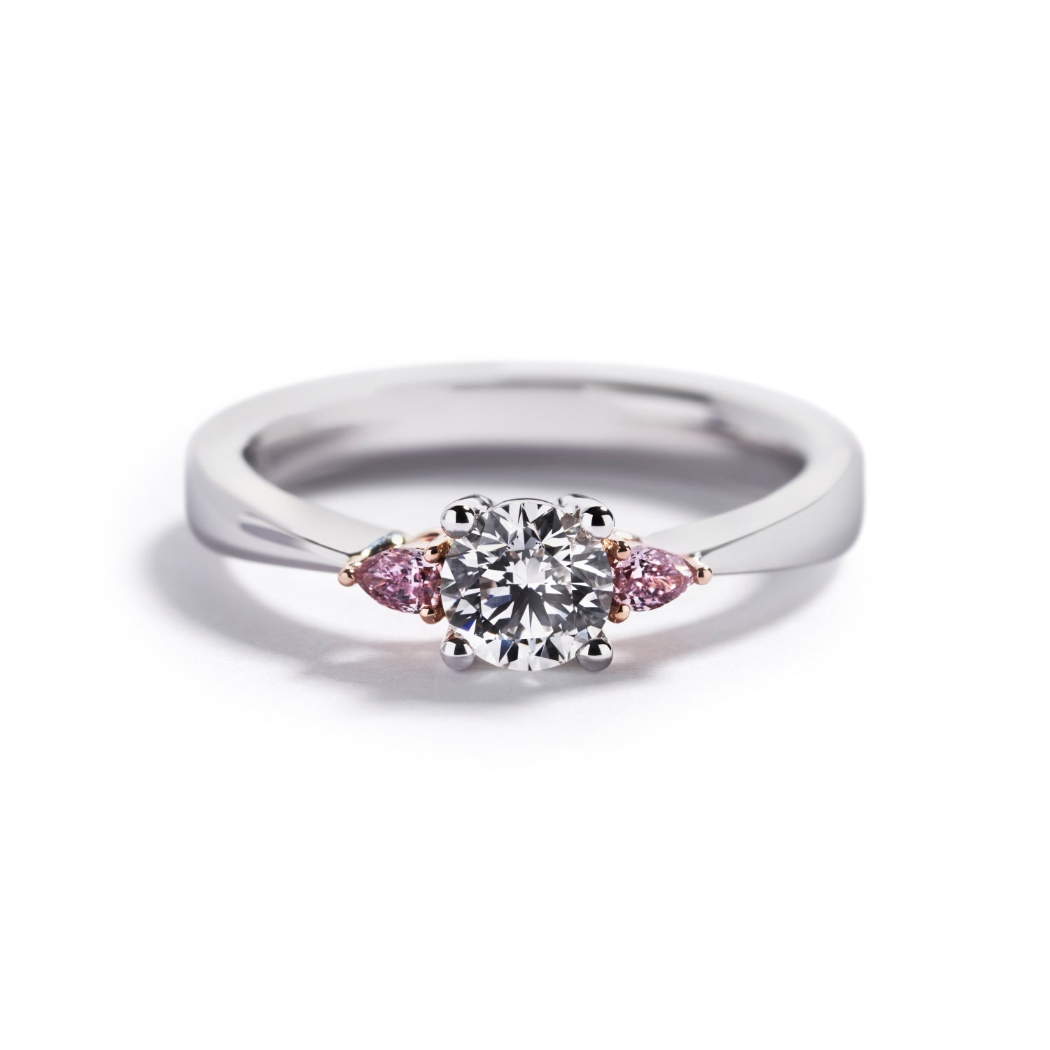 Trestensring i 18 kt. hvidguld prydet med en 0,52 ct. Top Wesselton(G)/VS1 brillant flankeret af to dråbeslebne Natural Fancy Intense Purplish Pink/SI diamanter, i alt 0,10 ct.  GIA certifikat medfølger.