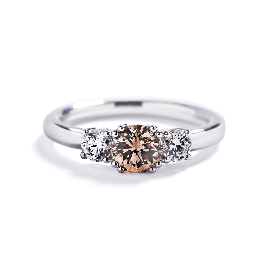 "Copenhagen Love" 3-stensring i 18 kt. hvidguld prydet med en 0,71 ct. champagne C5/VS1 brillant, flankeret af to Top Wesselton/VVS-VS brillanter, i alt 0,4