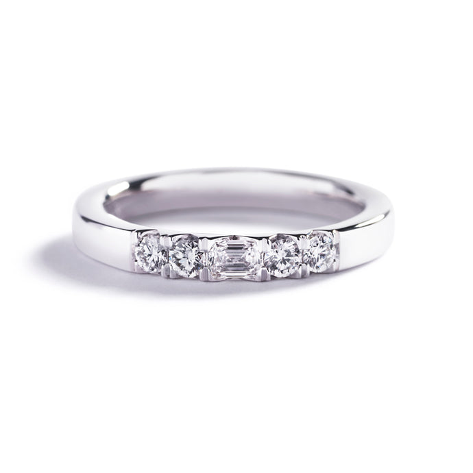 Alliancering i 18 kt. hvidguld prydet med en 0,15 ct. smaragdsleben Top Wesselton/VS diamant, flankeret af 4 Top Wesselton/VVS-VS brillanter, i alt 0,24 ct.