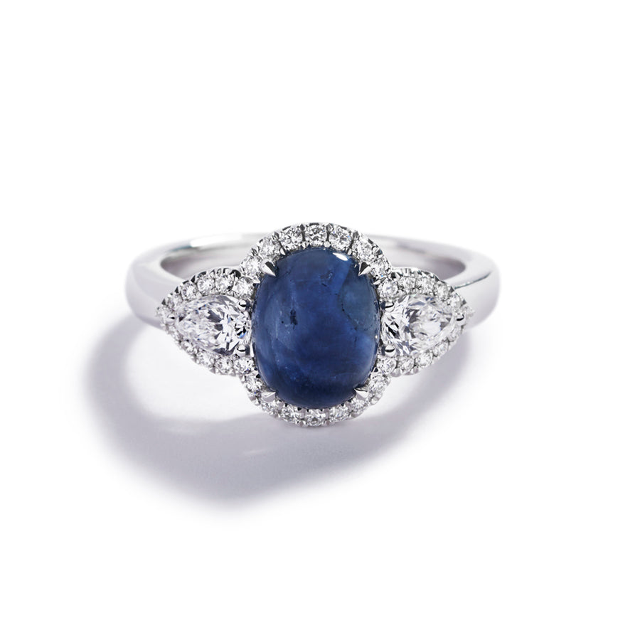 Safir 3-stensring i 18 karat hvidguld prydet med en 2,72 ct.
cabochonsleben Grønlandsk Blå Safir flankeret af to dråbeformede
Top Wesselton/VVS-VS diamanter, i alt 0,46 ct. samt 34
Top Wesselton/VVS-VS brillanter, i alt 0,24 ct.