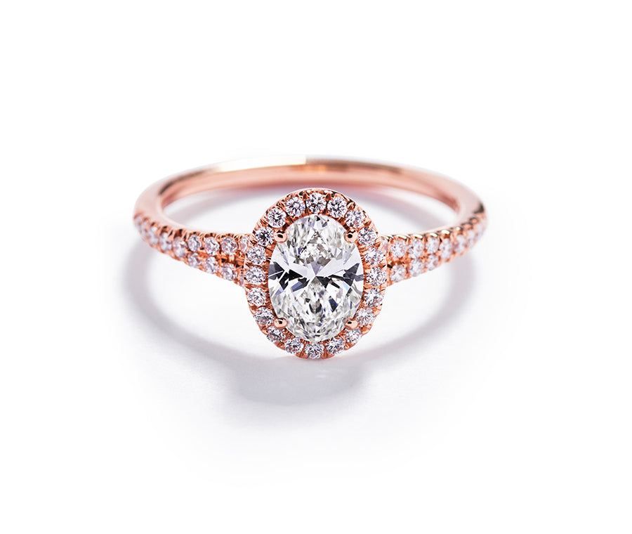 Rosétring i 18 kt. rosaguld prydet med 0,50 ct. ovalsleben Top Wesselton/VVS-VS diamant omkranset af 44 Top Wesselton/VVS-VS brillanter, i alt 0,24 ct. .   Fås også i 18 kt. gulguld og hvidguld