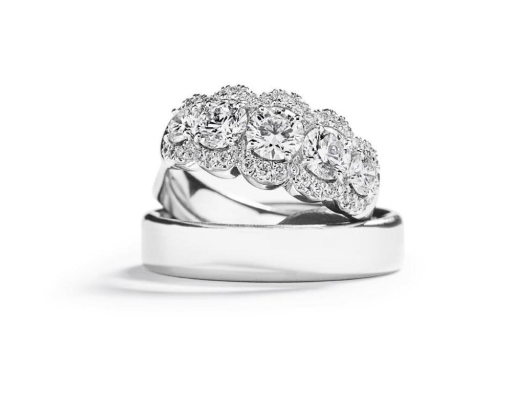 Femstensring i 18 karat hvidguld med hvide diamanter liggende ovenpå en herrering i platin